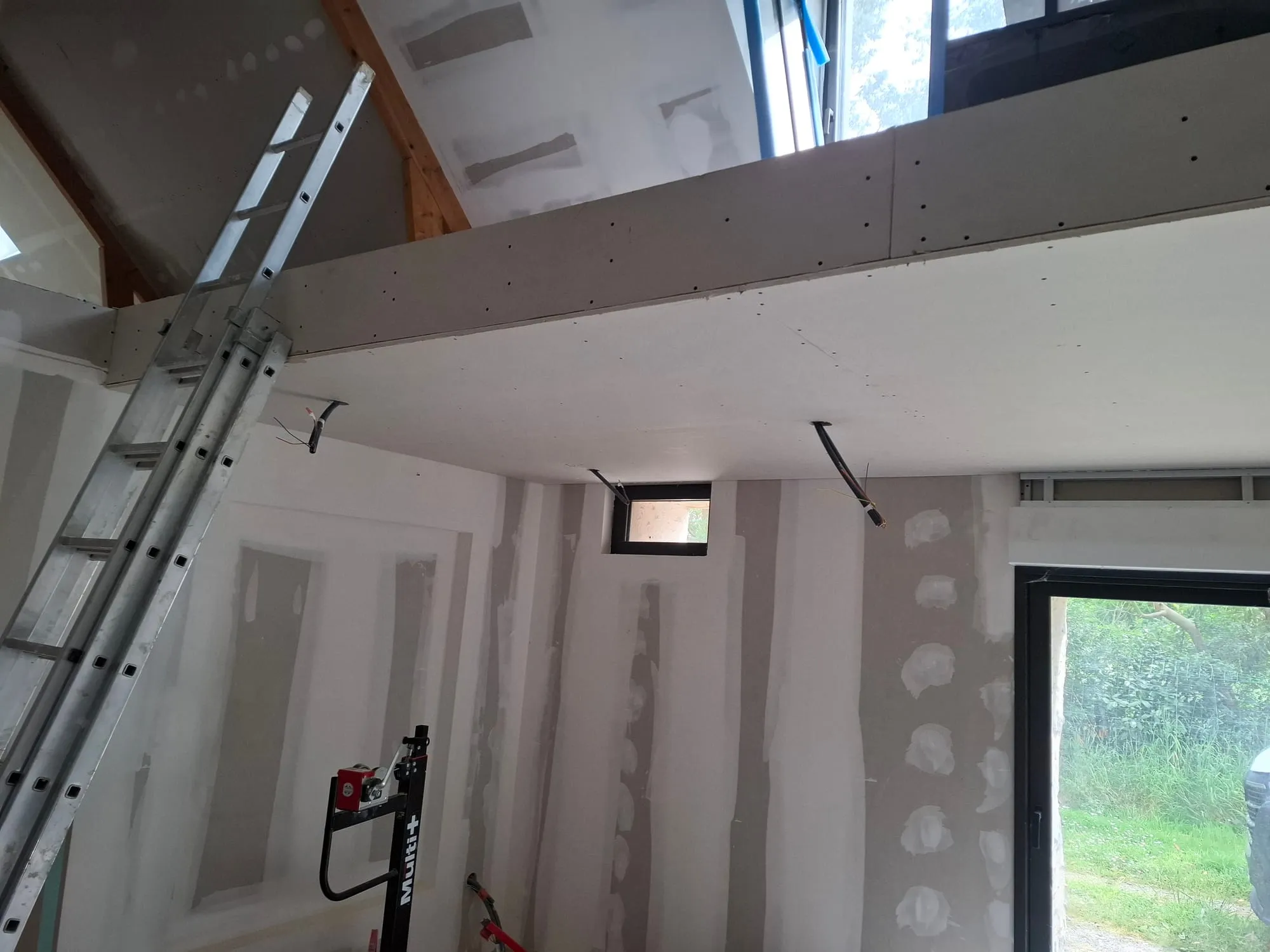 Doublage des murs et faux plafond en plaques de plâtre sous la charpente