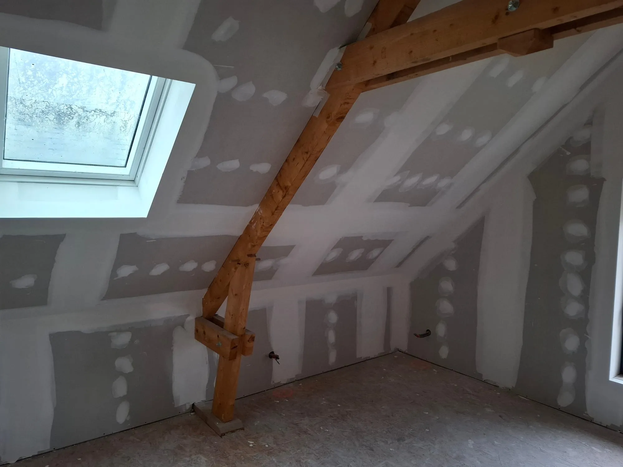 Rampants isolés et plaqués sous une fenêtre de toit dans une chambre des combles