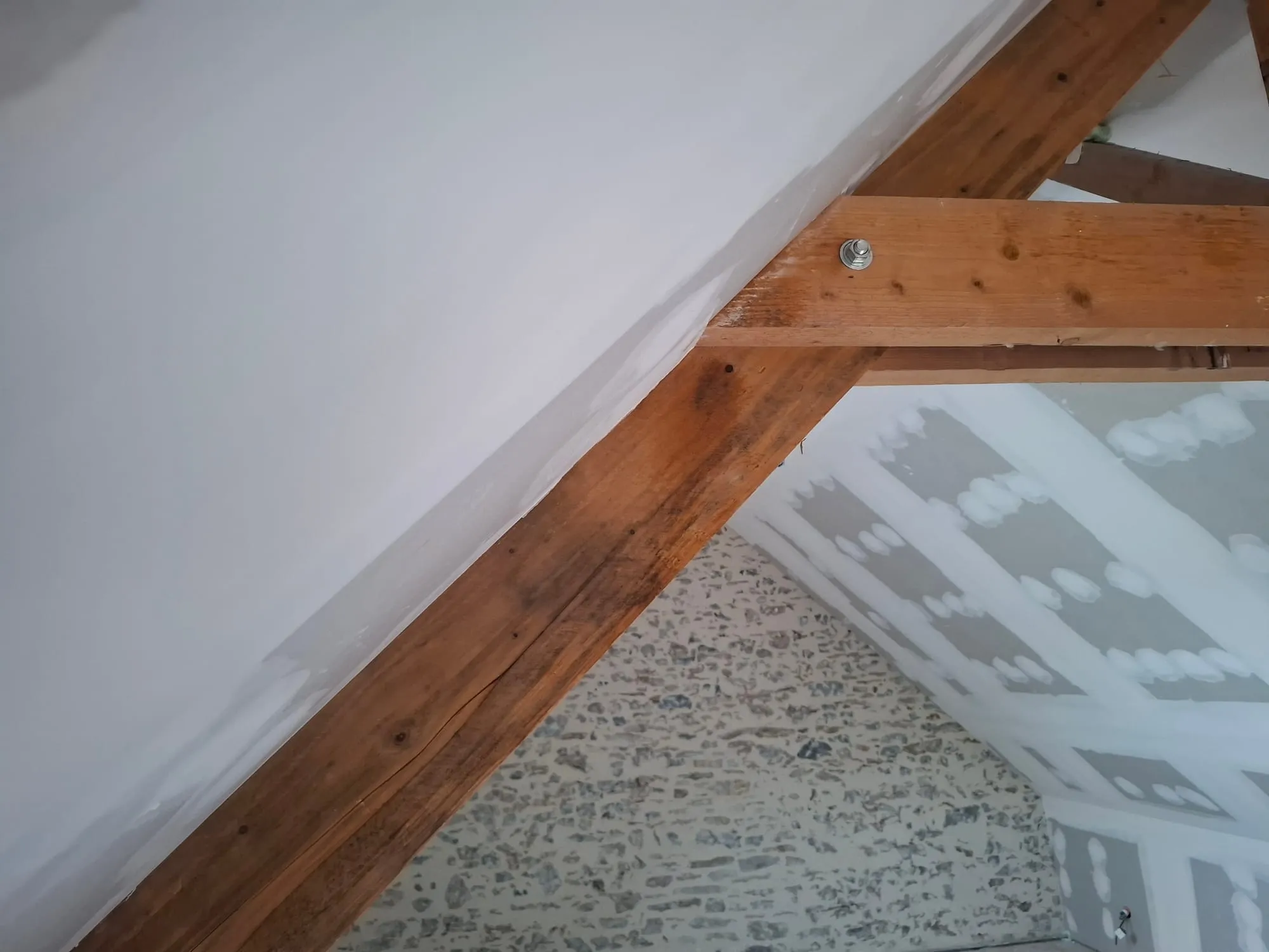 Rampant plaqué le long de la charpente conservée, à côté d'un mur en pierre